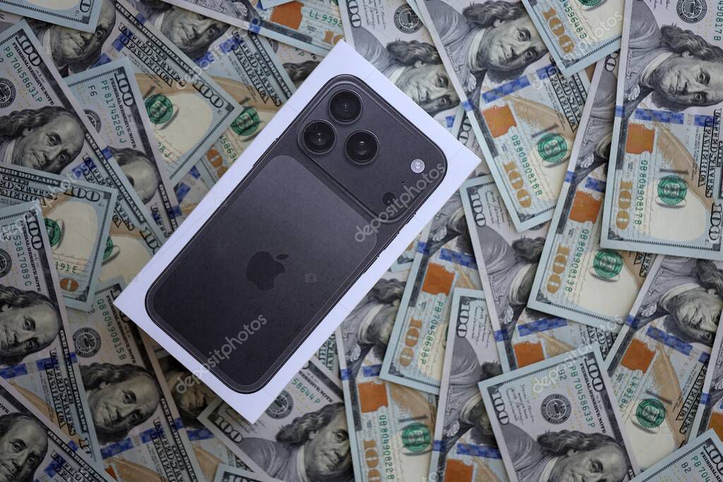 KYIV, UKRAINE - SEPTEMBER 21, 2025 Apple iPhone 17 Pro Max Black box on big amount of US dollar bills close up