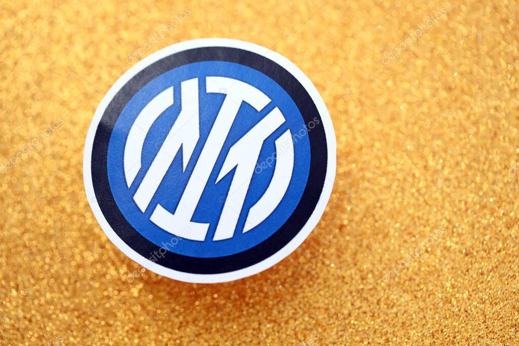 KYIV, UKRAINE - FEBRUARY 23, 2025 Inter Milan FC football club badge lies on golden yellow glitter background banner