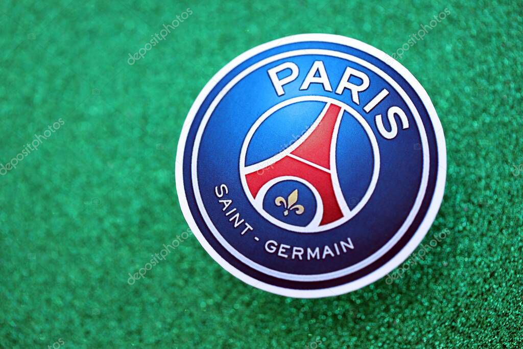 KYIV, UKRAINE - FEBRUARY 23, 2025 Paris Saint Germain FC football club badge lies on emerald green glitter background banner