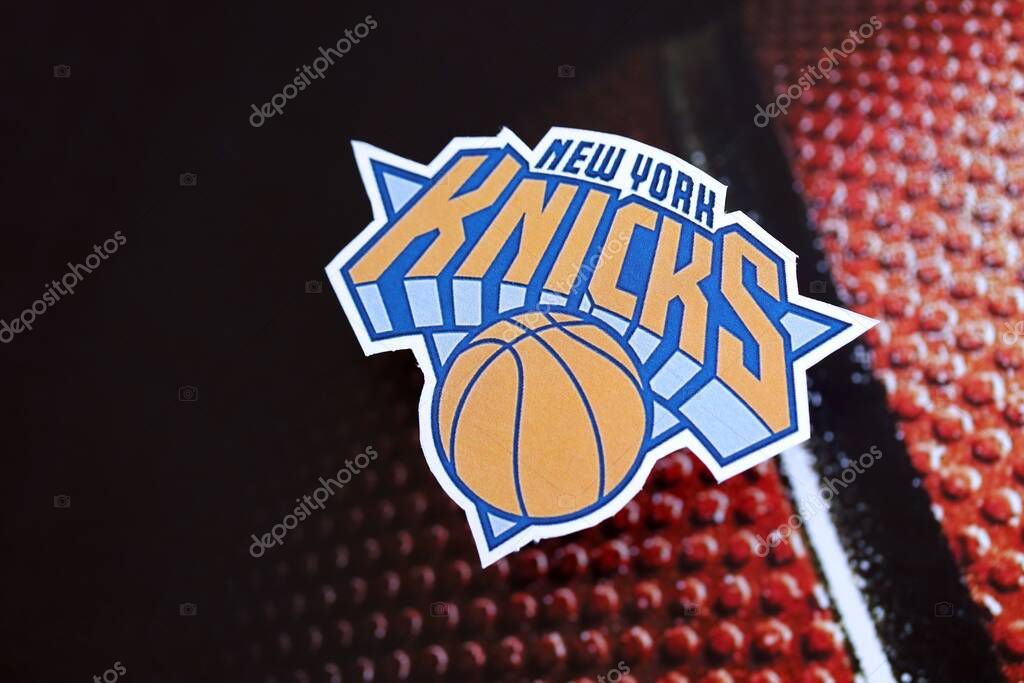 KYIV, UKRAINE - FEBRUARY 23, 2025 New York Knicks basketball team badge lies on basketball ball background banner