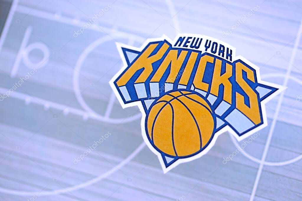 KYIV, UKRAINE - FEBRUARY 23, 2025 New York Knicks basketball team badge lies on basketball stadium map background banner