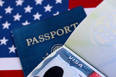 Pasaportlu ABD ziyaretçi vizesi ve Amerika Birleşik Devletleri bayrağı altında ABD pasaportu. Seyahat ve göç kavramı