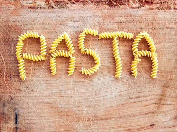 Pasta Palabra Hecha Con Pasta Fusilli Una Tabla Cortar Madera — Foto de Stock