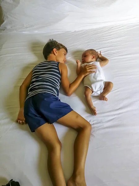 Brothers playing lay down on the bed