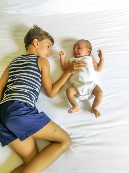 Brothers playing lay down on the bed