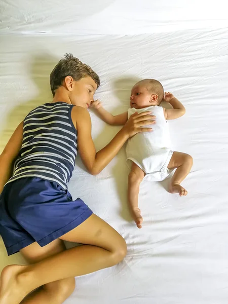 Brothers playing lay down on the bed