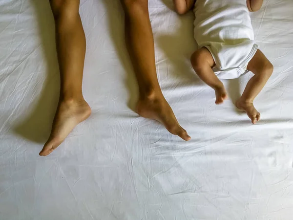 Legs and feet of two brothers lying in bed