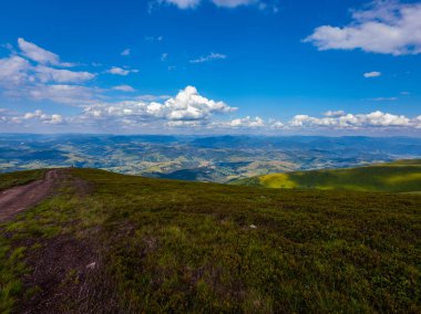 uzak dağlarda büyümüş yeşil çalılar ve otlar için kalın bulutların arasından güneş ışınlarının Parlatıcı, üstten görünüm