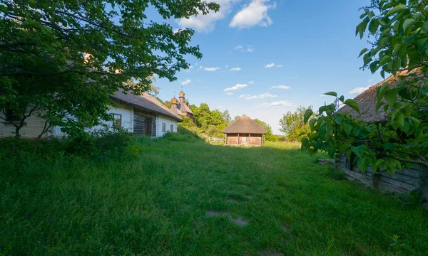 Długi, drewniany dom z stajni na porośnięte trawą stoczni. Użhorod, Ukraina — Zdjęcie stockowe