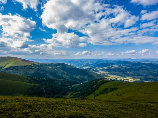 Belo vale de montanha verde grande contra um céu azul com nuvens brancas — Fotografia de Stock