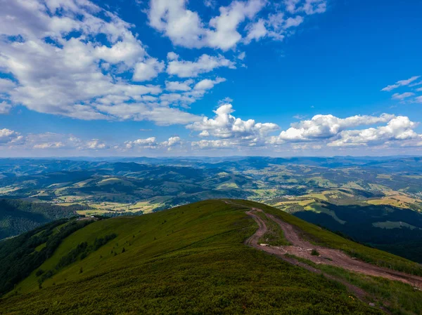 Uma bela paisagem montanhosa contra um céu azul brilhante e nublado. montanhas no horizonte — Fotografia de Stock