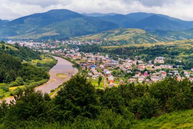 Bir nehir kanal bir tarafta ve diğer büyük bir yeşil dağ ayrılmış küçük bir kırsal köy