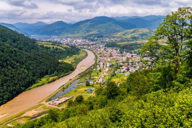 Yüksek bankalar ve fantastik dağ uzakta bulutların altında arasında gurgling dağ nehir