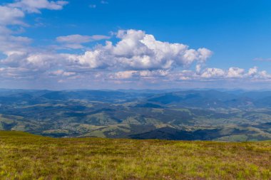 Büyük yeşil dağlar ve onların eteklerinde, küçük bir kırsal köy üstten güzel bir görünüm