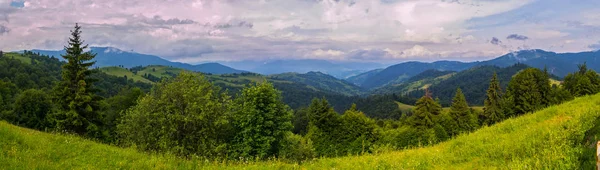 A picturesque view of the vast endless green Carpathian mountains against the blue sky with white clouds — Stock Photo, Image