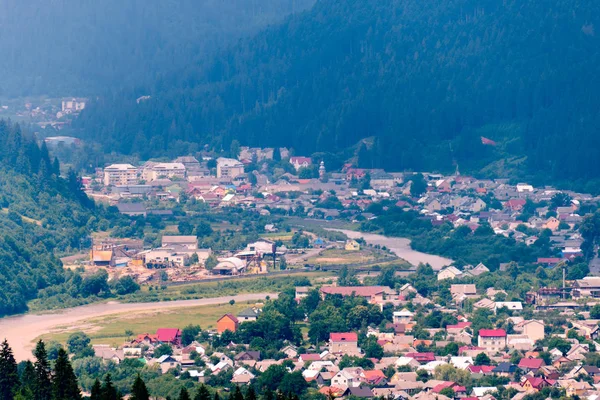 Vallée de montagne avec des maisons colorées entourées d'une haute forêt de conifères. L'endroit où la vanité de la ville est inconnue — Photo