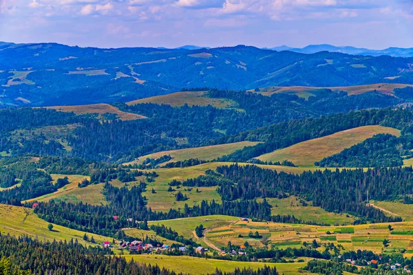 Malerische Landschaft bewaldeter Hügel mit grasbewachsenen Unebenheiten und landwirtschaftlichen Flächen — Stockfoto