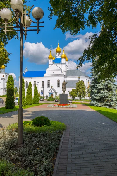 Пам'ятник лідеру на тлі великої красивої білої церкви з золотими куполами — стокове фото