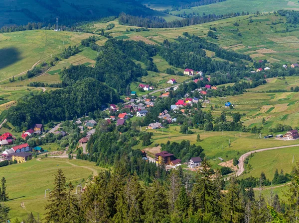 Yemyeşil ağaçlar ve büyük dağlar arasında güzel güzel evler ile küçük köylerde — Stok fotoğraf