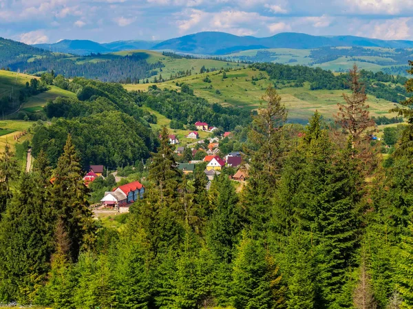 Gepflegte Häuser lauern an Berghängen versteckt hinter grünen Bäumen — Stockfoto