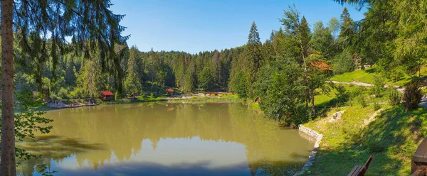 Зеленое озеро посреди большой парковой зоны с домами и местами для отдыха — стоковое фото