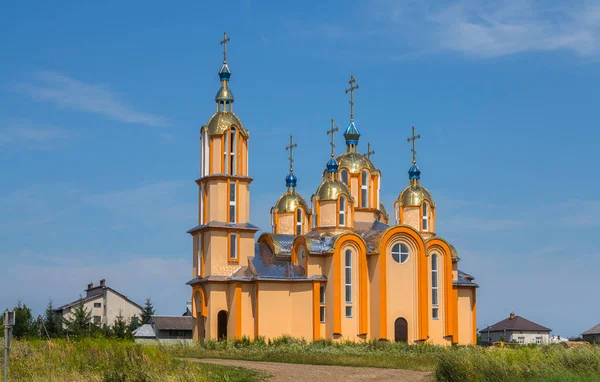 Велика помаранчева церква з величезною кількістю золотих куполів на тлі блакитного неба — стокове фото