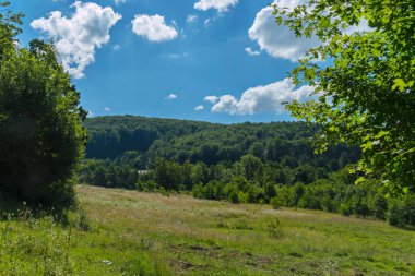 Yeşil bir dağ mavi gökyüzü beyaz bulutlar ile karşı yumuşak eğimli
