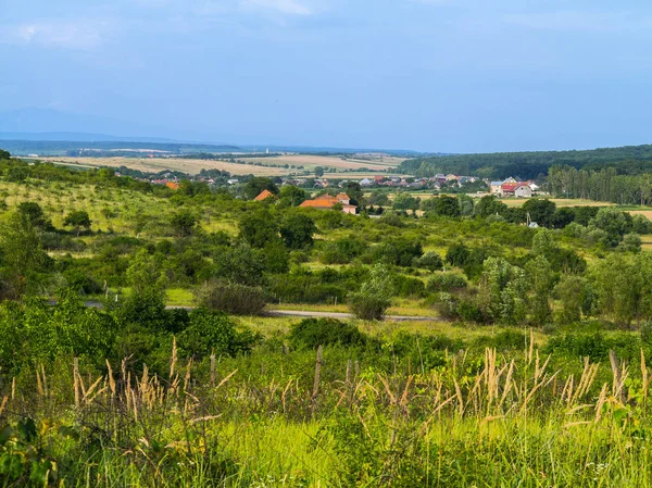 Невелике сільське село на фоні мальовничої зеленої зони і прокатних гір — стокове фото