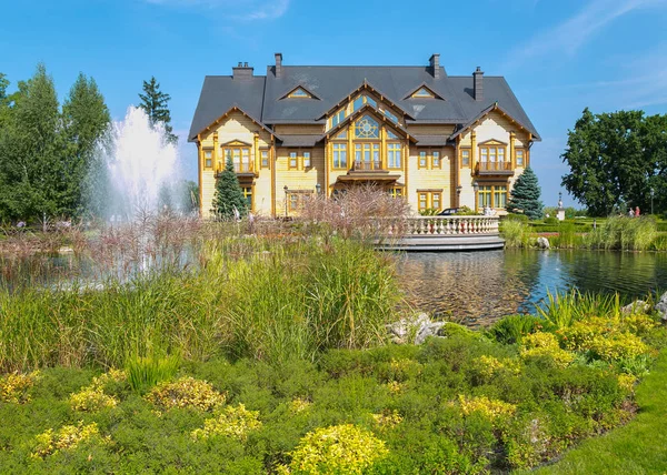 Una enorme casa de madera en el fondo de un lago con una fuente de gran impacto — Foto de Stock