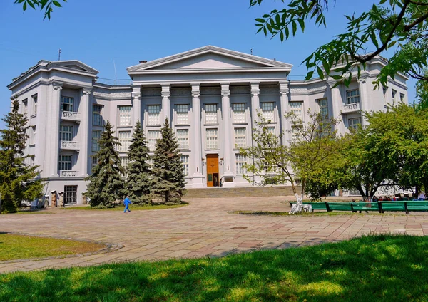 Weißes Verwaltungsgebäude mit Säulen und Fichte im Vordergrund — Stockfoto