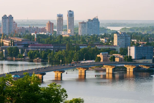 Un grand pont sur une large rivière et un paysage urbain de maisons à plusieurs étages en arrière-plan — Photo