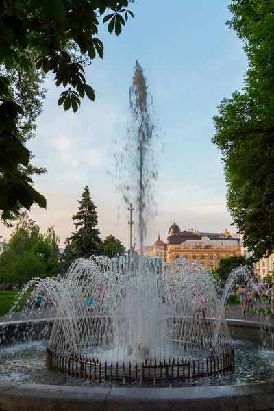 O alto spray de uma fonte voando sobre o fundo de um céu azul no parque da cidade derramar — Fotografia de Stock