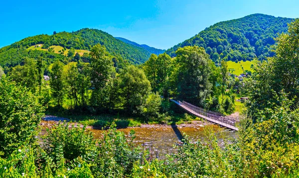 Pozastavené dřevěný most přes rychlé řeky spojující dvě banky s sebou — Stock fotografie