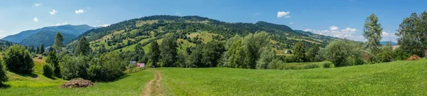 Panorama to the path leading to houses and mountains — Stock Photo, Image