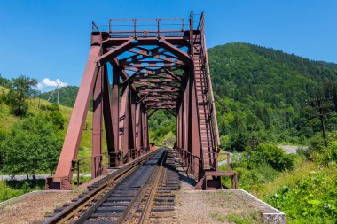 Yüksek yeşil dağların çerçevede Demiryolu Köprüsü'nün eski demir inşaat