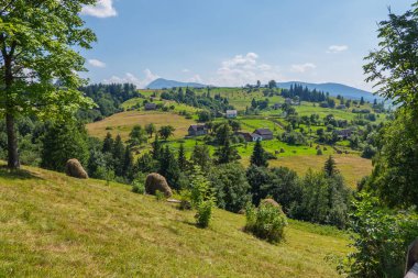 Nadir bulutlar güzel dağ manzarası ile küçük bir köy üzerinde asılı bir boğucu mavi gökyüzü.