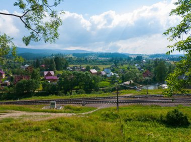 küçük bir köy ve uzak bulutlar asılı ile uzanan dağlar şık peyzaj