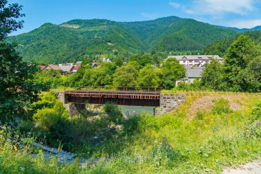 evler ve pitoresk yeşil dağlar uzakta çatılar arka plan üzerinde Demiryolu Köprüsü