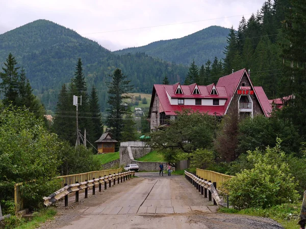 Un petit bâtiment hôtelier avec un toit rouge et une route qui y mène — Photo