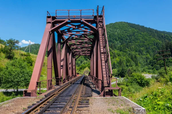 Yüksek yeşil dağların çerçevede Demiryolu Köprüsü'nün eski demir inşaat