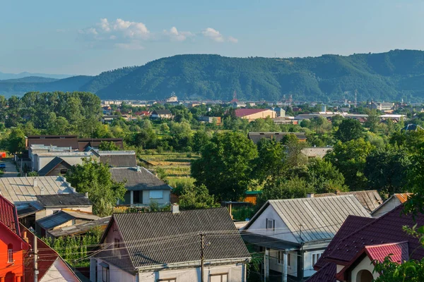 İmbuedly kayan bulutların üzerinde yeşil kısımları dağlar ve uykulu şehir