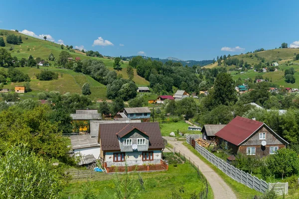 Panorama tepeler yeşil sokakları ile ve arka planda uzak dağların nadir binalar arasında yapıldı.