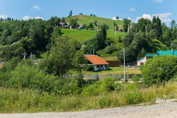 小さな民家とヤード緑山の斜面のふもと道 — ストック写真