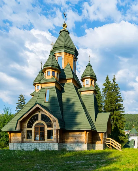 mavi bir bulutlu gökyüzü altında bir boynuz tepe üzerinde yeşil bir çatı ile ahşap Ortodoks Kilisesi