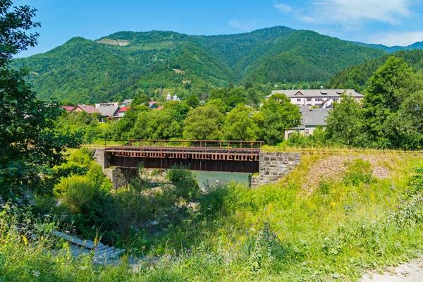 evler ve pitoresk yeşil dağlar uzakta çatılar arka plan üzerinde Demiryolu Köprüsü