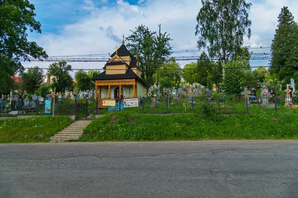 Vägen går längs kyrkogården med ett kapell som ligger bakom en böjd staket — Stockfoto
