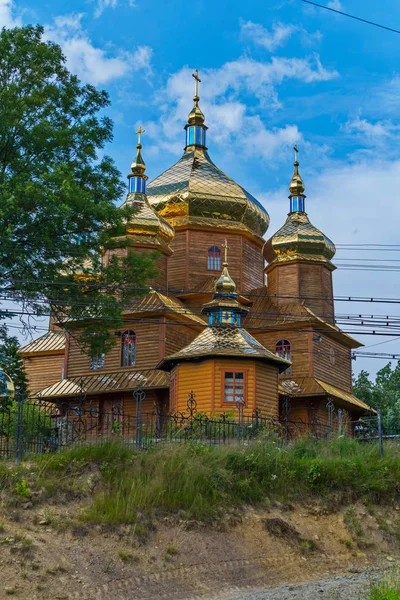 Чудова дерев'яна церква, що сяє золотими куполами на фоні блакитного неба — стокове фото