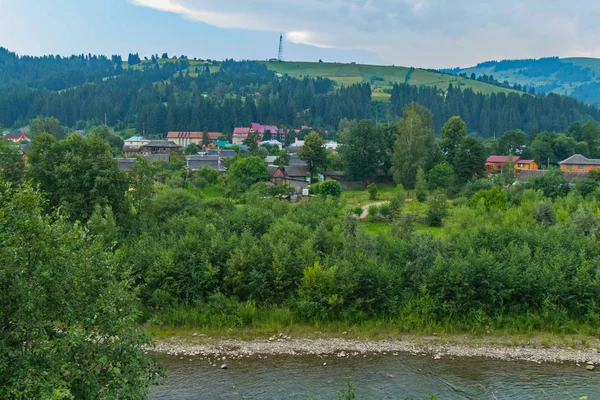 Der Fluss mit steinigen Ufern in der Nähe des Ferienortes, am Fuße des Hügels — Stockfoto