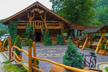 Otantik restoranı karmaşık ahşaptan inşa ve yeşil dağların arka plan üzerinde zemin ile döşeli. Dinlenmek için en iyi yer