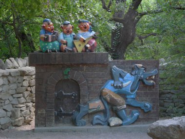 Bir duvar bir bıçak ve kaygısız domuz iskambil müzik aletleri ve şarkıları söyleyerek ile takip bir kurt ile şeklinde parkta neşeli bir heykel.